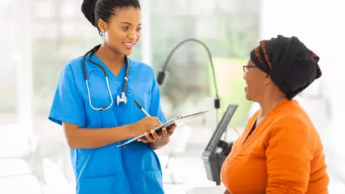 a patient talks with her doctor, both are women of color