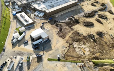 Mud and debris in the employee parking lot being pushed into piles for removal at the Baxter North Cove facility to get the site back online. Photo by Aerial Lens