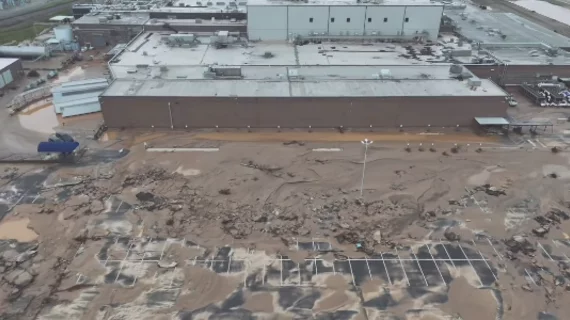 Employee parking lot is a sea of mud and storm debris at the the Baxter North Cove facility. Photo by Aerial Lens.